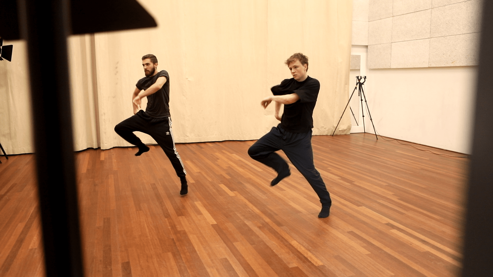 two dancers performing in a room with cameras